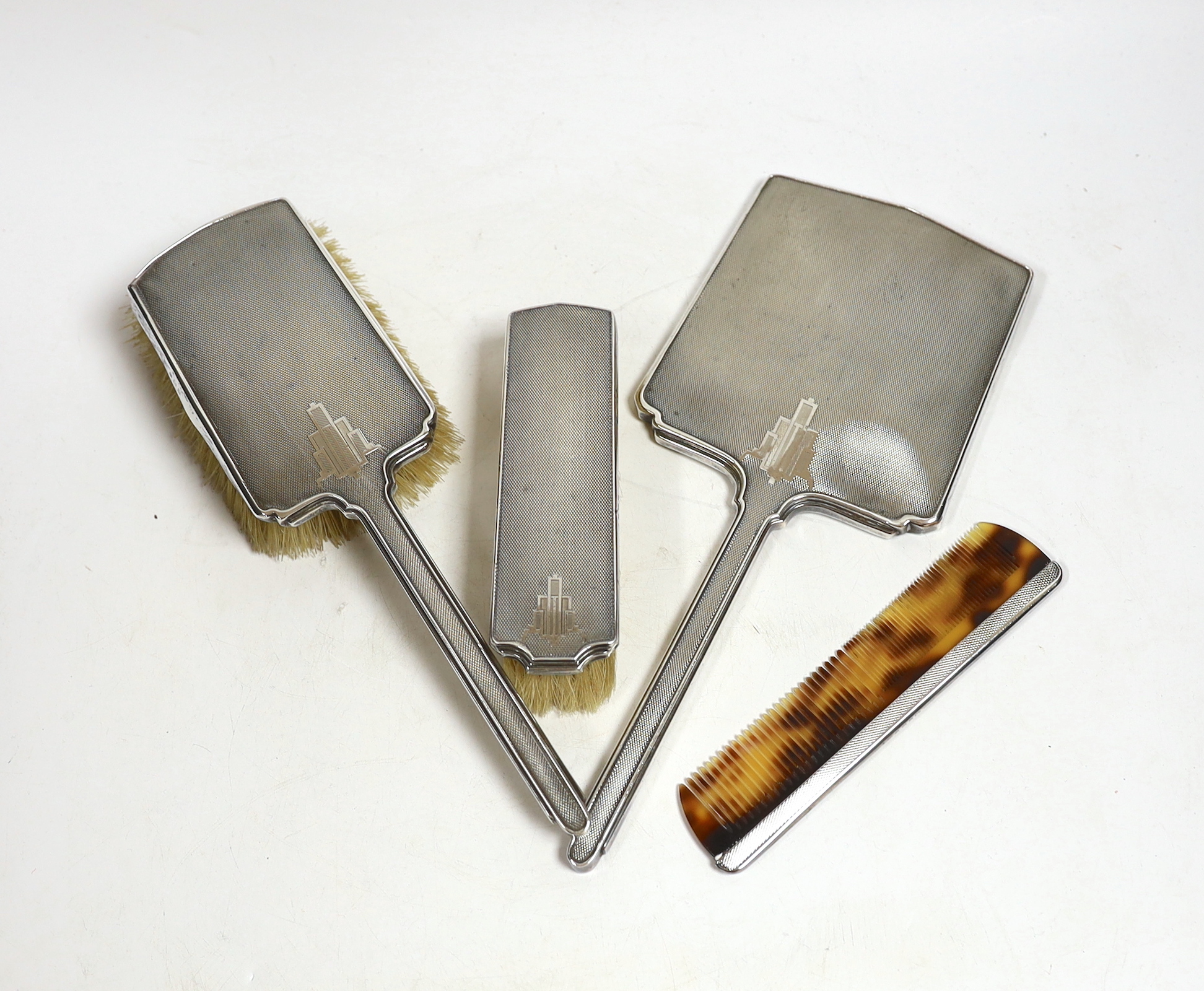 A George V Art Deco silver mounted four piece mirror and brush set, William Neale Ltd, Birmingham, 1933/36.
